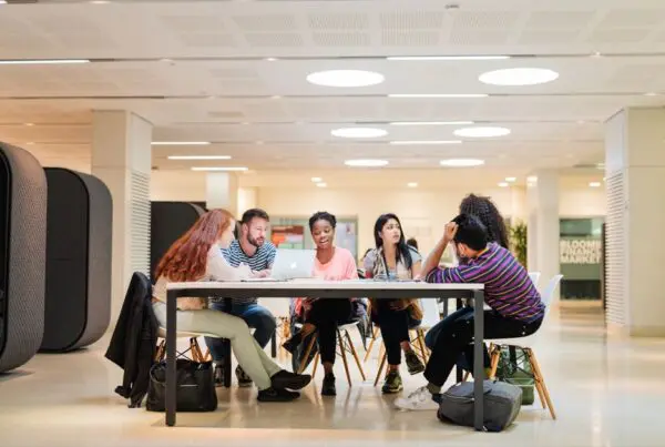 5 students seated at a table on Westminster's campus